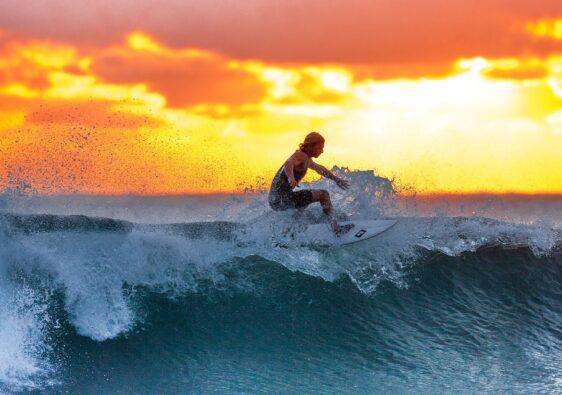Anstrengender als man denkt. Surfen ist ein echtes Workout! Eine große Welle reiten daher ein echter Traum.